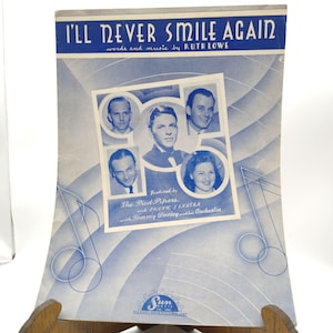 Könnte beinhalten: Vintage Notenblatt mit dem Titel "I'll Never Smile Again" von Ruth Lowe. Das Cover zeigt Porträts von The Pied Pipers, Frank Sinatra und Tommy Dorseys Orchester. Das Design ist in Blau- und Weißtönen gehalten, mit Noten.