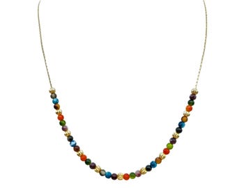 Puede incluir: Un collar con una cadena dorada y una hebra de cuentas redondas y coloridas. Las cuentas son de varios colores, incluyendo azul, verde, naranja y morado. El collar es de diseño sencillo y elegante.