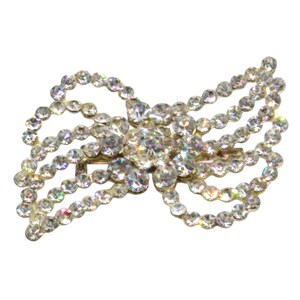 May include: A sparkling, silver-toned hair clip adorned with numerous clear, round rhinestones. The clip is designed in a bow shape, with multiple strands of rhinestones creating a layered effect. The rhinestones are set in a silver metal base.