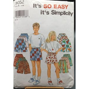 May include: Simplicity sewing pattern 9052 for sizes 7-14. The pattern includes instructions for making shorts with various prints, including plaid, floral, and dinosaur designs. The pattern is titled "It's SO EASY it's Simplicity".