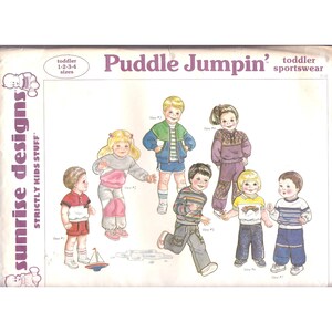May include: A sewing pattern for children's clothing, featuring seven different designs for toddler-sized outfits. The pattern is titled "Puddle Jumpin' Toddler Sportswear" and includes a variety of styles, including a jacket, pants, and a shirt with a rainbow graphic.