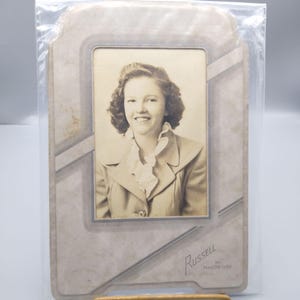 Foto de retrato vintage en papel de gabinete, original en blanco y negro de una joven encantadora con cuello con volantes, década de 1950, Russell Studios