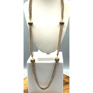 Może przedstawiać: Złoty naszyjnik wielorzędowy z czterema okrągłymi, fakturowanymi koralikami.