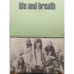 Könnte beinhalten: Ein Vintage-Notenblatt mit dem Titel "life and breath" mit Text von George Clinton. Die Noten enthalten ein Schwarz-Weiß-Foto einer Band. Der Preis beträgt 1,00 $.