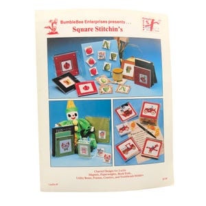 May include: A craft instruction leaflet titled Square Stitchin's by BumbleBee Enterprises. It displays various projects including lucite magnets, paperweights, book ends, frames, coasters, and toothbrush holders featuring cross-stitch designs.
