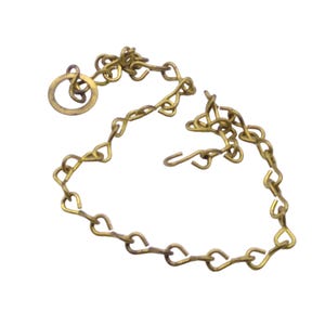 May include: A gold-colored chain with a ring at one end and a hook at the other. The chain is made of small, linked loops.