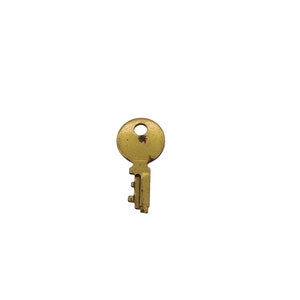 May include: A gold-colored key with a round head and a single, straight, serrated edge. The key has a worn, aged appearance.