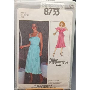 May include: Simplicity 8733 sewing pattern envelope featuring illustrations of two dresses. The envelope includes the text "time saver STRETCH knit" and size information. The dresses are a light blue and pink, with a ruffled design.