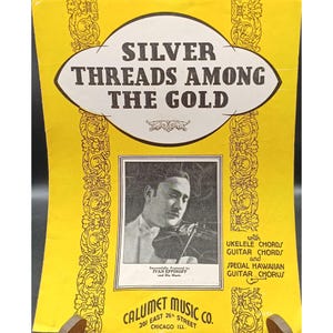 May include: A vintage sheet music cover, predominantly yellow, with the title "Silver Threads Among the Gold." It features a black and white image of a man playing a violin. The text includes "Calumet Music Co." and "Ukulele Chords and Special Hawaiian Guitar Chorus."
