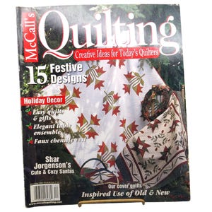 May include: McCall's Quilting magazine cover from December 2008 featuring 15 festive designs. The cover displays a white quilt with red and green maple leaf patterns, a holiday wreath, and text highlighting easy quilts, gifts, and table ensembles.