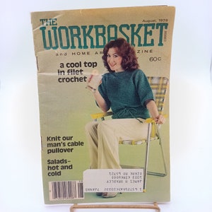 May include: The Workbasket magazine cover from August 1979 features a woman wearing a green crocheted top and white pants, sitting on a yellow and white striped lawn chair. The cover text reads "a cool top in filet crochet" and "Knit our man's cable pullover".