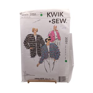 May include: A Kwik Sew pattern envelope 2031 for jackets in sizes XS-S-M-L-XL. The white paper envelope features illustrations of three jacket styles: one black and white fringed, one blue and pink fringed, and one solid pink jacket.