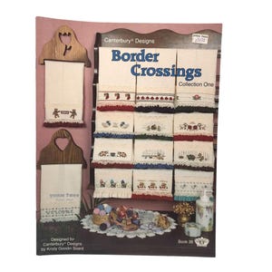 May include: A display of embroidered hand towels from the "Border Crossings" collection, featuring various designs and colors. The towels are displayed on a wooden rack, with a "Yarn Tree" towel holder in the foreground. The image also includes a price tag and the text "Book 38".
