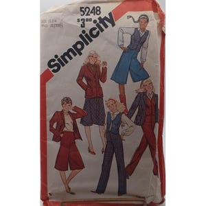 May include: Vintage Simplicity sewing pattern packet featuring illustrations of women's fashion from the 1970s. The packet shows various outfits, including suits, vests, and culottes. The cover is primarily white with red accents and the Simplicity logo.