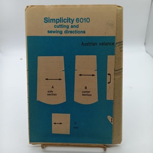Op de afbeelding: Simplicity naaipatroon nummer 6010 voor een Oostenrijkse valance. Het patroon bevat instructies voor het knippen en naaien van de valance. De afbeelding toont een diagram van de valance met labels voor de zijsectie, de middelste sectie en het einde.