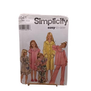 Könnte beinhalten: Eine Simplicity 5941 easy-to-sew Schnittmusterhülle mit Illustrationen von vier Kindern in verschiedenen Nachtwäsche-Stilen, darunter ein gemustertes Nachthemd, ein rosa Kleid, ein gelber Morgenmantel und ein rosa-weiß karierter Schlafanzug.