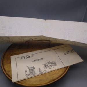 May include: A white paper model kit with the number 2750 printed on it. The kit is for a "Double Building" and includes instructions for building a model of a building with a clock tower.