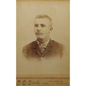 Antica foto di un giovane uomo in abito e papillon, risalente al 1890, proveniente da una cartolina di C.E. Clark, Holdrege, Nebraska