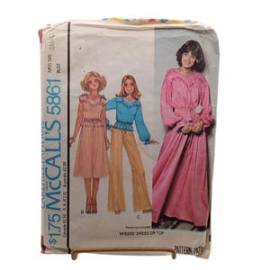 May include: A McCall's 5861 sewing pattern envelope for a misses' dress or top. The front features illustrations of three outfits: a pink dress, a blue top with tan pants, and a long pink dress. Text includes "McCall's 5861" and "Misses' Dress or Top".