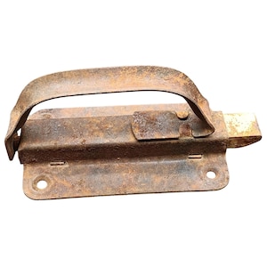 Puede incluir: Un pestillo de metal oxidado con un asa curvada. El pestillo tiene un cuerpo rectangular con un cerrojo deslizante y dos orificios de montaje. El metal está muy corroído, mostrando signos de edad y desgaste. El asa es arqueada.
