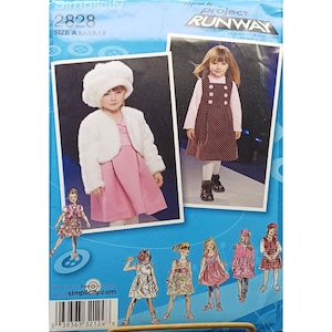 May include: Simplicity sewing pattern 2828, size A, featuring images of girls' dresses and outfits. The pattern includes a pink dress with a white fur jacket and a brown polka dot dress. The text "Inspired by Project Runway" is visible.