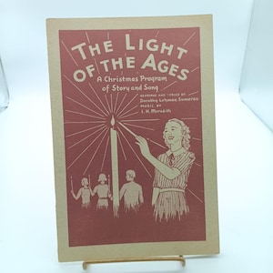 Puede incluir: Un folleto rojo y blanco titulado "The Light of the Ages: A Christmas Program of Story and Song". La portada muestra a una mujer encendiendo una vela con una cerilla, y tres otras figuras de pie detrás de ella.