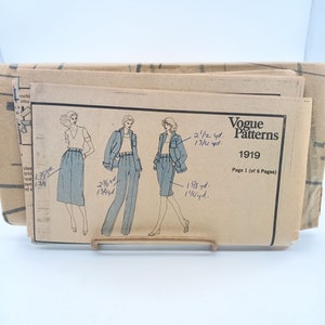 May include: A vintage Vogue Patterns sewing pattern, featuring illustrations of a skirt suit, pants suit, and shorts suit. The pattern envelope is beige with the Vogue Patterns logo and the number 1919. The page reads "Page 1 (of 6 Pages)."