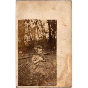 Carte postale ancienne REXO RPPC avec photo d'une jeune fille dans une scène de nature