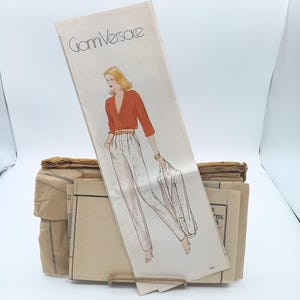 Pode incluir: Um padrão de costura vintage com uma ilustração de moda de uma mulher com um top vermelho, calças brancas e um casaco. O padrão é rotulado "Gianni Versace" e faz parte de uma coleção de padrões.