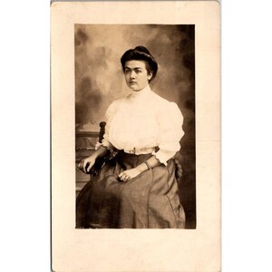 Carte postale ancienne de Kruxo RPPC, belle jeune femme dans une chaise de studio parure