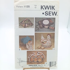 May include: A sewing pattern for making various kitchen items, including a bread basket, a hot pad, a chicken-shaped bread warmer, and a bread holder. The pattern is from Kwik Sew Pattern Co., Inc. and is number 1135.