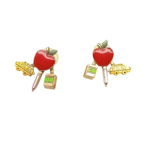 May include: A pair of gold-toned earrings with a school theme. Each earring features a red apple with a green leaf, a pencil, a book labeled "MATH", and a yellow school bus. The earrings are set against a white background.