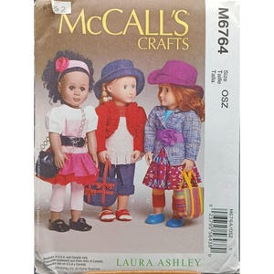 May include: McCall's Crafts sewing pattern M6764 with doll clothing designs. The pattern shows three dolls in different outfits, including dresses, jackets, and hats. The cover displays the text "McCall's Crafts" and "LAURA ASHLEY".