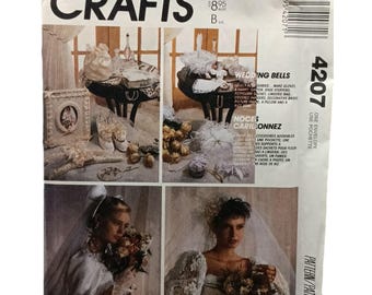 May include: A vintage McCall's Crafts pattern envelope featuring the title "Wedding Bells." The cover displays images of bridal accessories, including gloves, shoe stuffers, and a lingerie bag. The pattern number is 4207.
