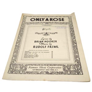 May include: Vintage sheet music for "ONLY A ROSE", with lyrics by Brian Hooker and music by Rudolf Friml. The cover has decorative floral borders and the publisher's details: Famous Music Corporation, 1619 Broadway, New York.