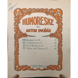 May include: Sheet music for "Humoreske" by Anton Dvořák. The cover features an orange and brown decorative border around the title. The text includes "Original in Gb," "Simplified in G," "Four Hands in G," and "Violin and Piano in G."