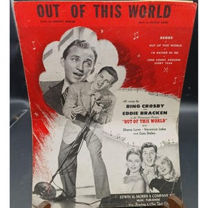 Puede incluir: Portada de partituras de "Out of This World" con ilustraciones de Bing Crosby y Eddie Bracken. La portada roja y blanca incluye títulos de canciones y créditos, con los nombres de Diana Lynn, Veronica Lake y Cass Daley.