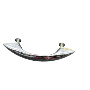 May include: A chrome-finished cabinet pull handle with a curved design. The handle is attached with two silver screws. The pull handle is approximately 5 inches long.