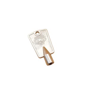 May include: A silver-toned key for a National Cabinet Lock. The key has a pointed tip and a flat, rectangular head with the words "National Cabinet Lock" printed on it.