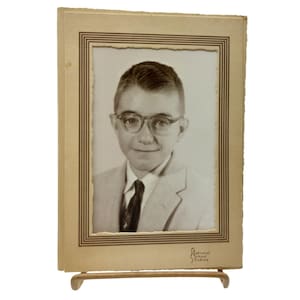 Fotografía antigua en cartulina, original en blanco y negro de un niño con gafas de National School Studios