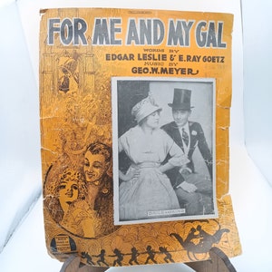 May include: A vintage sheet music cover for the song "For Me and My Gal" by Edgar Leslie and E. Ray Goetz, with music by Geo. W. Meyer. The cover features a black and white photo of a couple in formal attire, with the woman wearing a white dress and a hat, and the man wearing a suit and a top hat. The cover is yellowed with age and has a worn, vintage look.