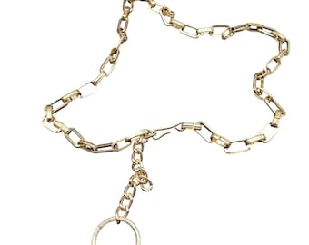 Cinturón vintage de eslabones de cadena de eloxal en tono dorado con dije circular texturizado.