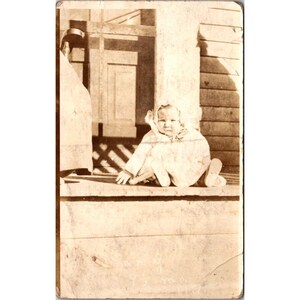 Carte postale photo authentique RPPC bébé sur le porche vers début des années 1900, véritable sépia