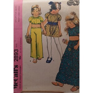May include: Vintage McCall's sewing pattern 2893 for child's top, skirt, pants, and dress. The illustration shows three children's outfits: a yellow crop top and pants, a floral dress, and a floral top and skirt. The pattern includes the text "CHILD'S TOP, SKIRT, PANTS AND DRESS".