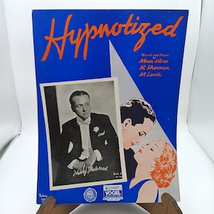 Puede incluir: Una portada de partitura vintage para una canción titulada "Hypnotized" con una foto en blanco y negro de un hombre con esmoquin y una foto en color de una pareja abrazándose. La partitura acredita la canción a Abner Silver, Al Sherman y Al Lewis.