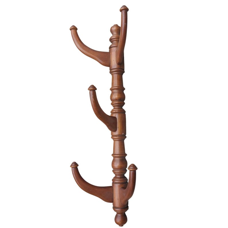 Pu&ograve; includere: Appendiabiti in legno marrone scuro con tre bracci curvi. Il palo decorativo &egrave; tornito, con estremit&agrave; arrotondate. I bracci sono distanziati per appendere cappotti, cappelli e accessori. Altezza di circa 170 cm.