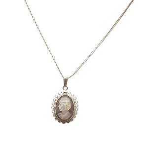 May include: A silver-toned necklace featuring an oval cameo pendant. The pendant showcases a profile portrait within a decorative frame. The chain is delicate, and the cameo has a light-colored background with a detailed figure.