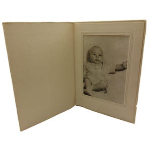 Foto vintage de bebé en marco de cartón texturizado color crema
