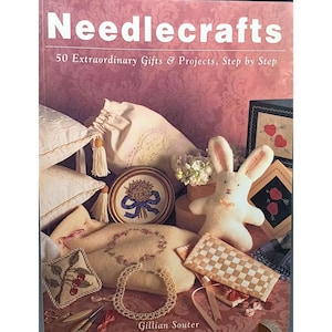 May include: A book titled "Needlecrafts" with the subtitle "50 Extraordinary Gifts & Projects, Step by Step." The image displays various needlecraft projects, including embroidered pillows, a bunny, and framed art, in soft, pastel colours.