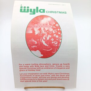 May include: A vintage advertisement for Wyla lace and trims, featuring a red and white illustration of a Christmas scene with a decorated tree and stockings. The text reads "Wyla Christmas" and "For a warm inviting atmosphere, spruce up hearth and home with Wyla lace and trims. Create a very special Christmas with an ambiance of elegance and grace at Holiday time! Let your imagination run wild! Wyla's new Christmas Assortments of laces and trims, with the ideas and suggestions inside, will help you design and develop holiday projects to delight you and your loved ones at that special time of the year!"